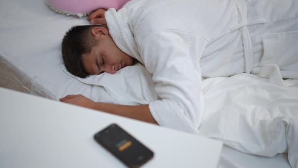Ένας Νεαρός Λευκό Μπουρνούζι Ξύπνησε Ξαπλωμένος Στο Κρεβάτι Στην Κρεβατοκάμαρά — Αρχείο Βίντεο