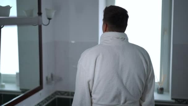 Young Guy White Bathrobe Approaches Mirror Bathroom Man Has Just — Stock Video