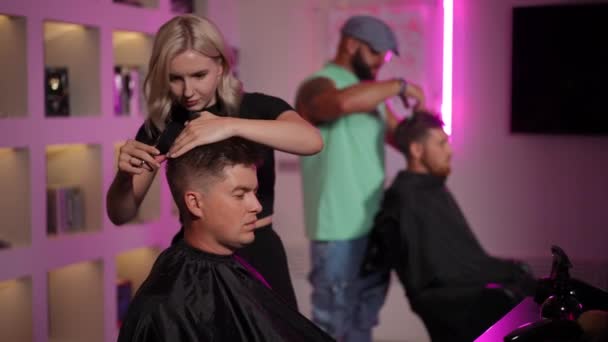 专业理发师用梳子和理发剪刀理发 理发师站在现代沙龙里 一边做男人的发型 慢动作 — 图库视频影像