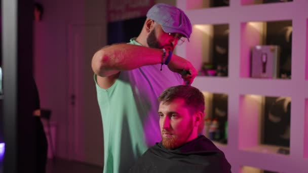 Stylowy Fryzjer Rozmawia Dając Mężczyzn Fryzurę Stojąc Nowoczesnym Salonie Fryzjerskim — Wideo stockowe