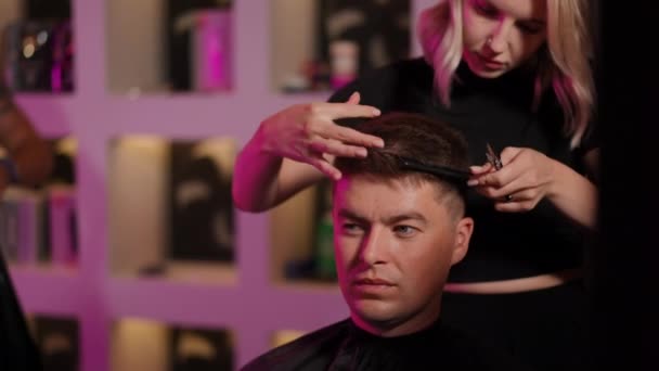 Młoda Kobieta Fryzjer Obcina Męskie Włosy Stojąc Nowoczesnym Salonie Fryzjerskim — Wideo stockowe