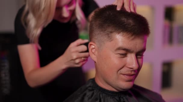 一个女理发师在现代美发厅里给一个理发的男人理发 慢动作 — 图库视频影像