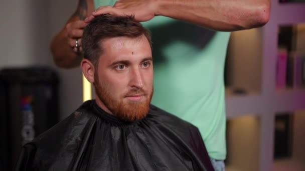 Zbliżenie Twarz Młodego Mężczyzny Pociętego Nożyczkami Fryzjerskimi Przez Początkującego Fryzjera — Wideo stockowe