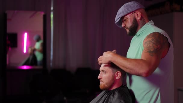 时尚的男性理发师在用理发师剪刀剪头发的同时给男性客户讲故事 慢动作 — 图库视频影像