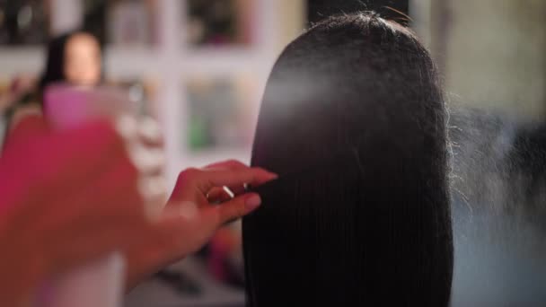 クローズアップ スローモーション 女性の美容師は 髪の長い髪の女性のヘッドマネキンにヘアメイクスプレーヤーから水をスプレーし それを組み合わせる — ストック動画
