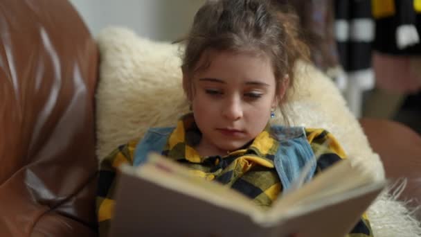 Дівчина Читає Книгу Починає Позіхати Лежачи Дивані Вітальні Сучасного Будинку — стокове відео