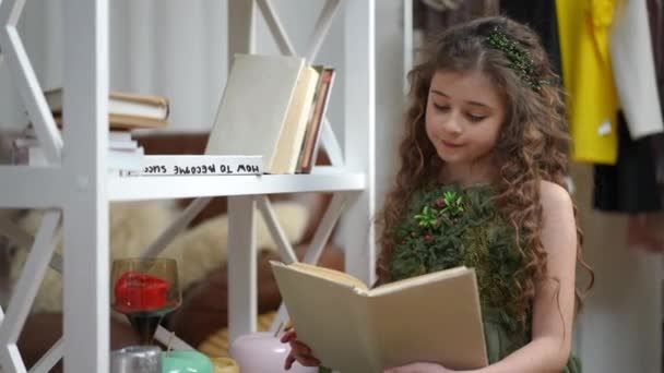 Симпатична Дівчина Довгим Волоссям Модному Зеленому Платті Читає Книгу Посміхається — стокове відео