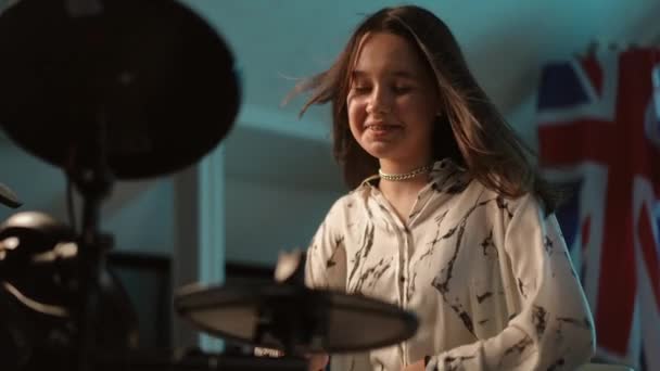 スローモーション クローズアップ 若い少女ミュージシャンが音楽学校のスタジオに座って電子ドラムキットを演奏しながら笑ったり笑ったりする — ストック動画