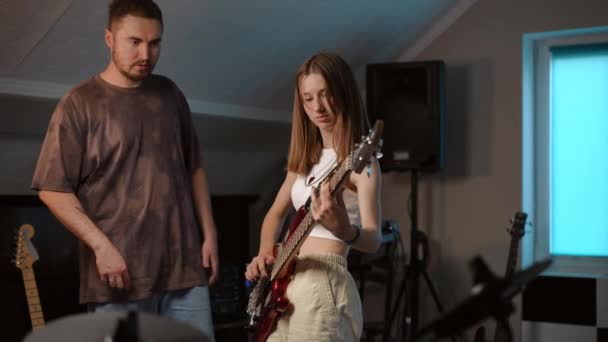慢动作一位女吉他手在一所音乐学校排练时 弹低音吉它 听导师的指导 — 图库视频影像