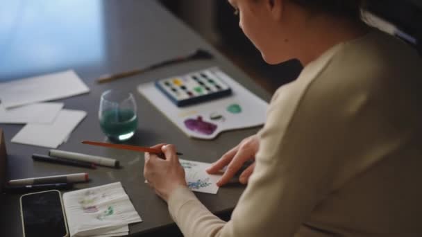 Kartka Życzeniami Kobieta Maluje Kartkę Farbami Akwarelowymi Siedząc Przy Stole — Wideo stockowe