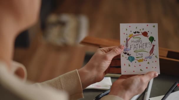 Kobieta Trzyma Kartkę Życzeniami Dnia Ojca Którą Namalowała Akwarelą Siedząc — Wideo stockowe