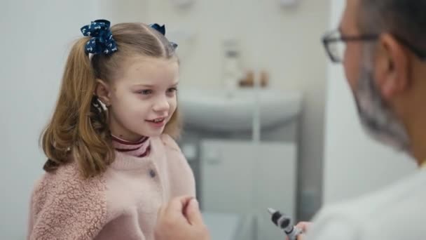 Pediatra Realiza Exame Visual Orelha Uma Menina Paciente Sentada Sofá — Vídeo de Stock