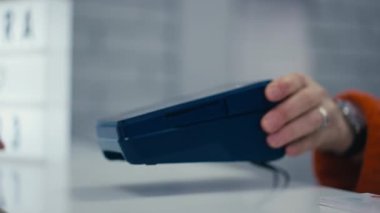 Yakın plan. Bir kadın cep telefonu kullanarak NFC teknolojisini kullanarak ödeme yapıyor. Cep telefonunda NFC. NFC kullanarak ödeme
