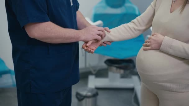 Oigenkännlig Man Läkare Mäter Pulsen Hos Oigenkännlig Gravid Kvinna Som — Stockvideo