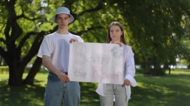 Bir adam ve bir kız, bir yaz günü bir parkta ağaçların arasında dikilirken kameraya bakar ve ellerinde bir poster tutarlar. Poster gezegeni kurtarın diyor.