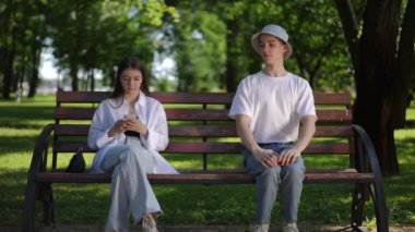 Güneşli bir yaz gününde sokak buluşma parkı. Güneş şapkalı genç bir adam elinde cep telefonuyla oturan bir kızın oturduğu bankta oturuyor ve onu tanımaya çalışıyor.