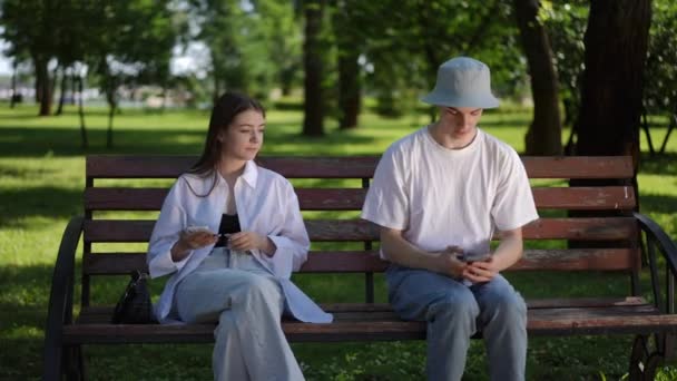 Güneş Şapkalı Genç Bir Adam Elinde Cep Telefonuyla Bankta Oturan — Stok video