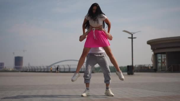 才华横溢的舞者表演街头舞蹈的复杂元素 一个男人和一个女孩优美而巧妙地表演着复杂的舞蹈动作 这对夫妇笑着看着摄像机 — 图库视频影像