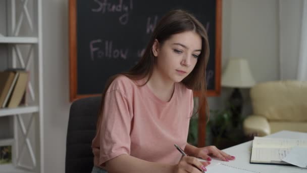 Una Chica Con Pelo Largo Escribe Con Bolígrafo Bloc Notas Video de stock libre de derechos
