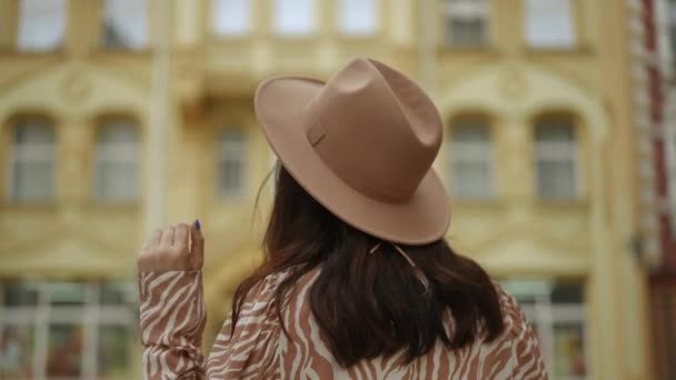 Μια Μελαχρινή Γυναίκα Ένα Στιλπνό Καπέλο Στρέφεται Κομψά Προς Την — Αρχείο Βίντεο