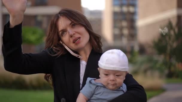 Nærbillede Forretningskvinde Holder Baby Sine Arme Taler Mobiltelefon Vinker Hendes – Stock-video