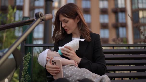 Une Femme Affaires Nourrit Bébé Avec Biberon Parle Sur Téléphone — Video