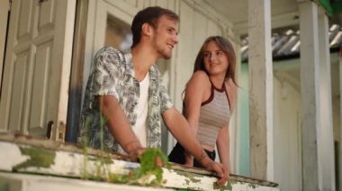 Ağır çekim. Mutlu bir evli çift, güneşli bir yaz gününde verandada duruyor. Adam kıza eliyle sarılıyor, onlar da uzaktan bakıp gülümsüyor.