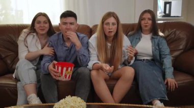 TV ekranında maçı izlerken kazanmanın sevinci. Arkadaşlar plastik bardaktan patlamış mısır yer ve ekranda olanlara duygusal tepki verirler. Bir grup arkadaş izlerken...