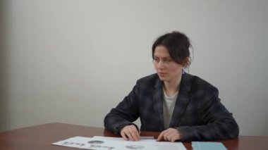 İki iş kadını kahve molasında iş konularını tartışıyor. Ofisteki masalarında oturuyorlar.