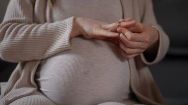 Hamileliğini kucaklayan hamile bir annenin şefkatini ve sevgisini yakalayan huzurlu ve güzel bir an.
