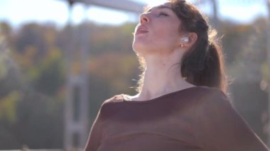 Kendine güvenen bir kadın zarif bir şekilde doğada duruyor, içsel gücünü ve derin sakinliğini tamamen kucaklıyor.