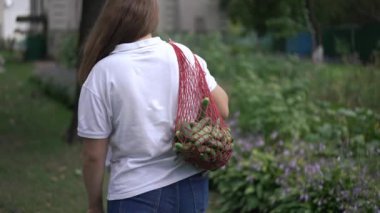 Bir insan, içi taze ve sağlıklı ürünlerle dolu bir çantayla gezintiden keyif alır.