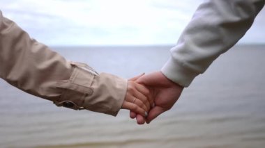 Ağır çekim. Güzel, romantik bir an başlıyor. Sevgi dolu bir çift, sakin ve sakin sahil kenarında el ele tutuşurken.