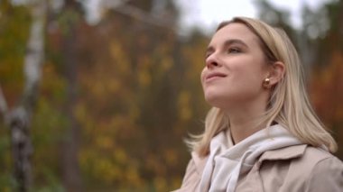 Huzurlu genç bir kadın sonbahar boyunca doğanın güzelliğinden zevk alır, sükuneti ve yansımayı somutlaştırır..