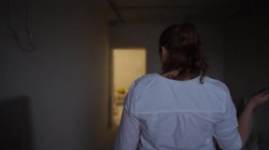 Bir kadın, evin gelişiminin özünü vurgulayan bir silindir kullanarak iç mekanı boyamaya hazırlanıyor.