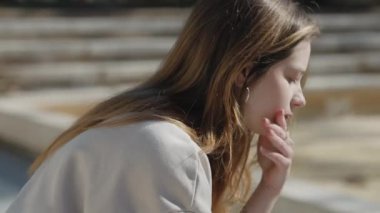 Düşüncelere dalmış genç bir kadın doğal güzelliğini gösterir ama kalbi mutsuz aşkla kırılır.