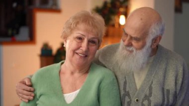 Gülümseyen yaşlı bir çiftin, tatil sezonunda sevgi ve sıcaklık saçan yakın çekimi. Neşeli ifadeleri, şenlikli bir atmosferde beraberlik ve şefkat ruhunu yansıtıyor..