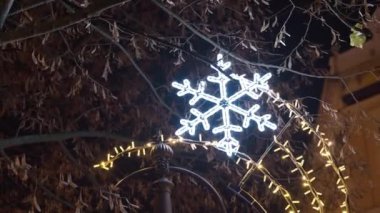 Parıldayan ışıklarla aydınlatılmış güzel bir kar tanesi, bayram ruhunu mükemmel bir şekilde yakalıyor.