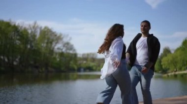 Su kenarında güzel romantik bir an, doğadaki sevgi ve bağlantının özünü ustalıkla yakalıyor.