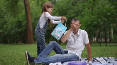 Neşeli bir baba kızı, yemyeşil bir parkta gülüşmeler ve aşkla dolu neşeli bağlarını yakalar.