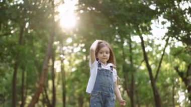 Küçük bir çocuk, bereketli, güneşli bir ormanda çocukluk sevincinin özünü yakalayan neşeli bir anın tadını çıkarır..