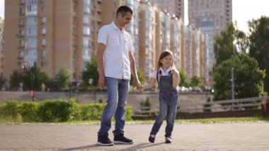 Sevgi dolu bir ebeveyn ve sevimli bir çocuk arasında güneşli bir şehir parkında güzel bir şekilde yakalanmış hoş ve neşeli bir an.