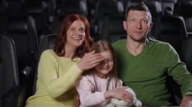 Bir aile, ortak deneyimlerin güzelliğini vurgulayarak tiyatro ortamında keyifli bir anın tadını çıkarır..