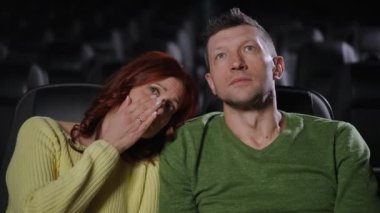 Çift sinemada romantik bir drama izliyor. Kadın gözle görülür şekilde duygusal, gözyaşlarını silerken, erkek onu nazikçe rahatlatır ve rahatlatır. Film sırasında özel bir an paylaşıyorlar.