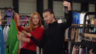 İki moda blogcusu seyircilerini canlı yayın yoluyla bir butikte canlı kıyafet parçaları sergiliyorlar. Akıllı telefon tutarak takipçilerle iletişim halindeler.