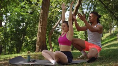 İki bireyin aktif olarak meditasyon ve rahatlama uygulamaları yaptığı sakin ve sakin bir açık hava ortamı.