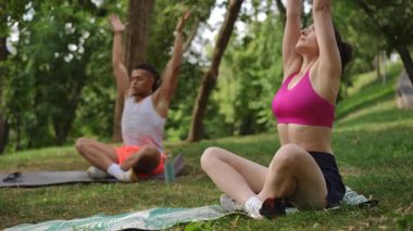 Katılımcılar yoga seanslarının bir parçası olarak huzurlu bir açık hava ortamında meditasyon uygulaması yaptılar. Eğitmen ve öğrenciler sakin ve odaklanmış durumdalar. Elleri dua pozisyonunda.