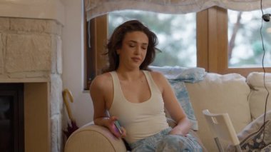 Bir kadın rahat ve kaygısız bir anın tadını çıkarıyor rahat evinde, rahatlığın ve gündelik yaşamın özünü sergiliyor.