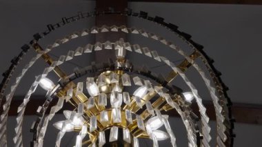 Göz kamaştırıcı bir avize. Kristal tasarımlar ve parlak bir aydınlatma sergiliyor.