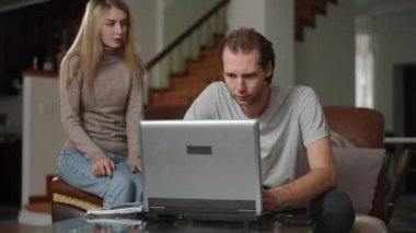 Bir erkek ve bir kadın şık bir oturma odasında rahatça otururken canlı bir dijital tartışmaya giriyorlar.